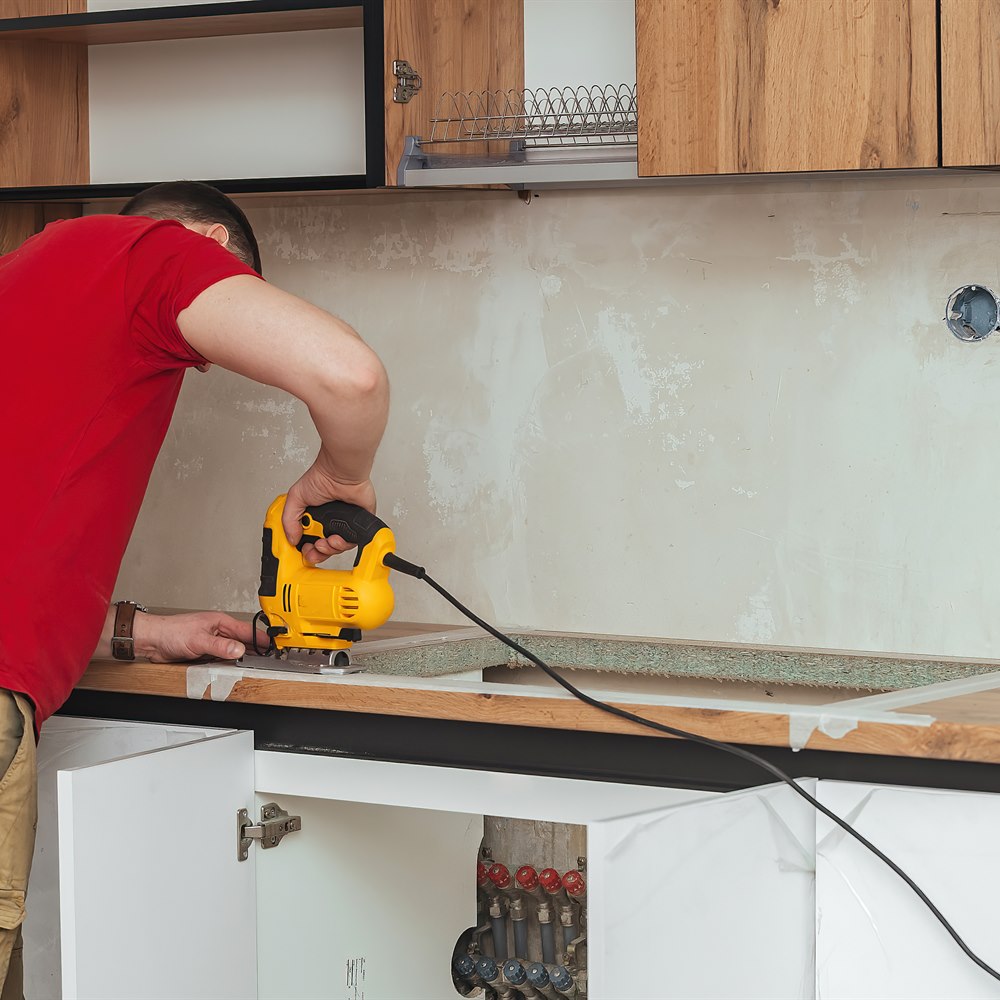 Man uses power saw in kitchen renovation