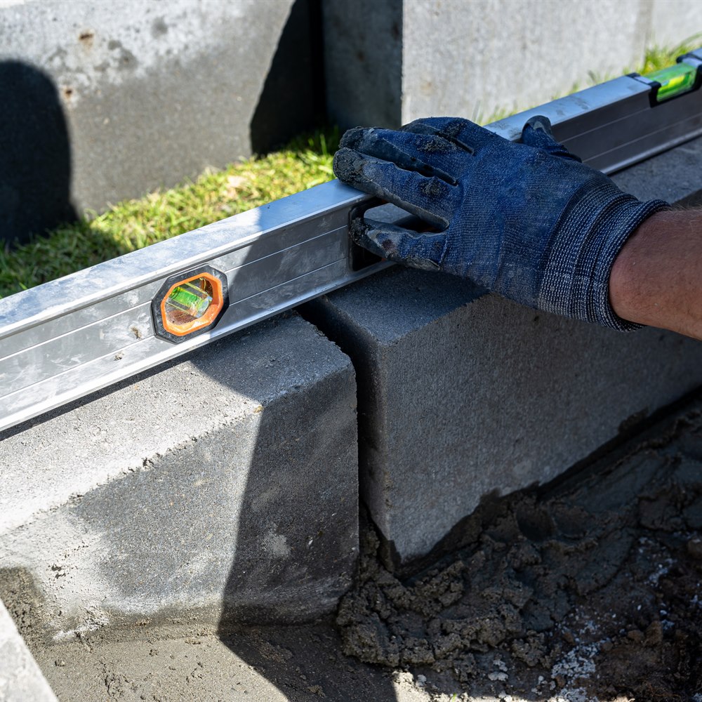 Man using level building with cinder blocks