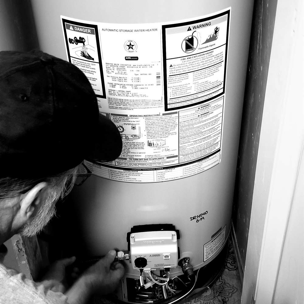 Man working on an automatic storage water heater