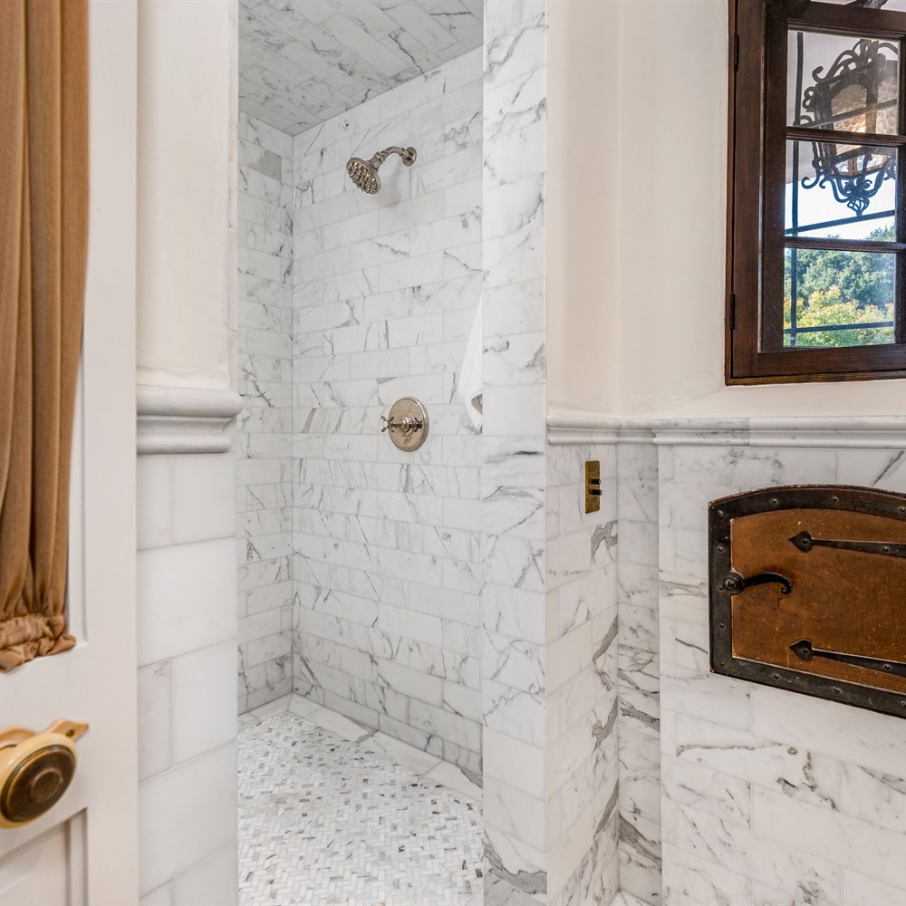 Marble bathroom with shower and bronze fixtures