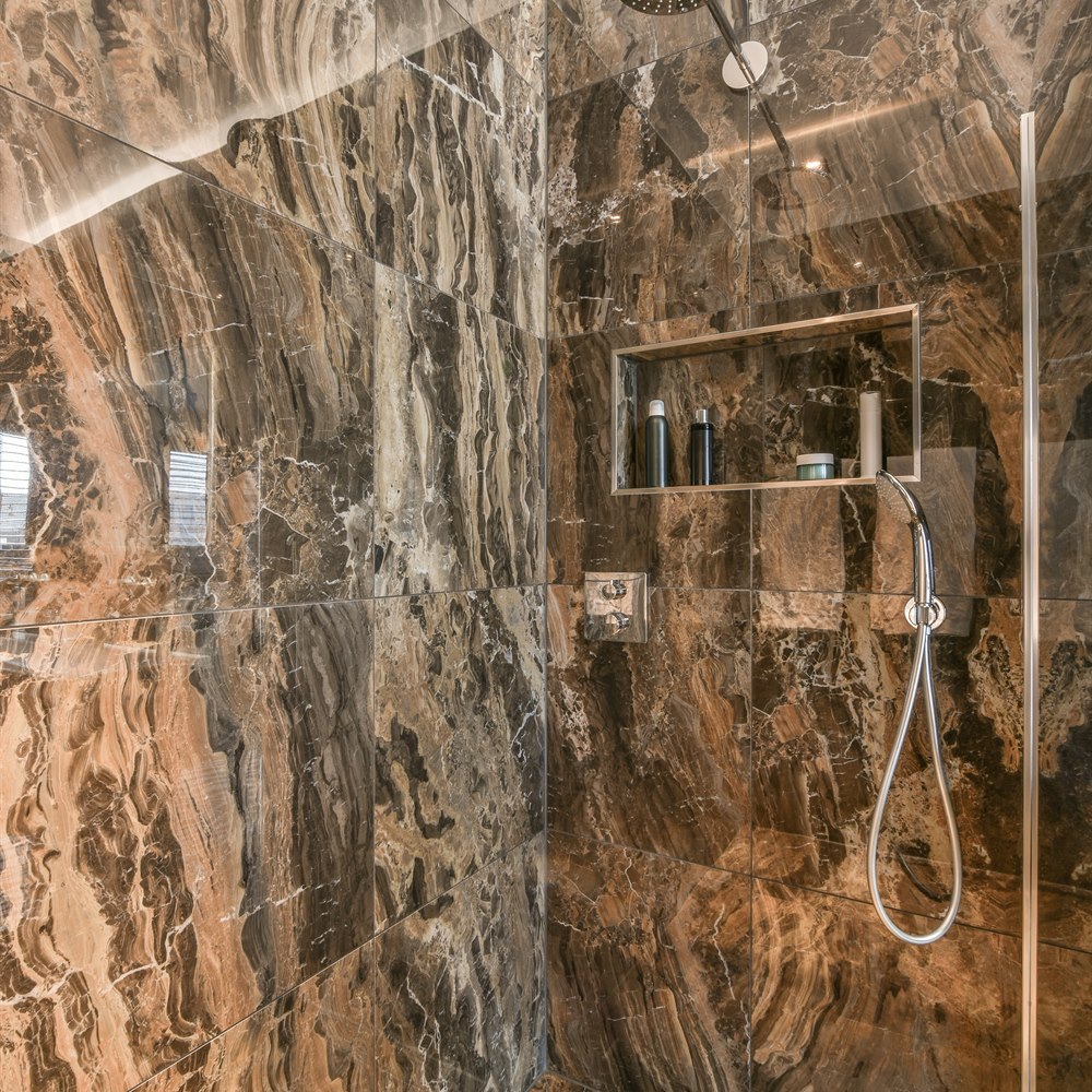 Modern brown marble shower with chrome fixtures
