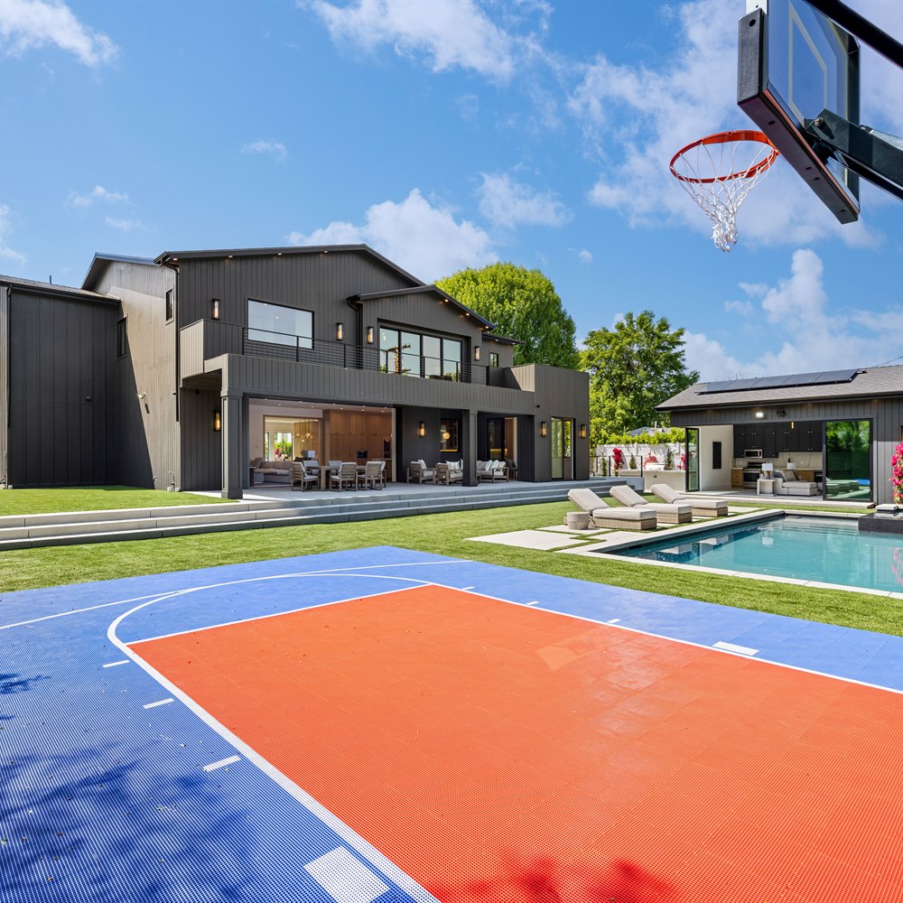 Modern home exterior with pool and basketball court