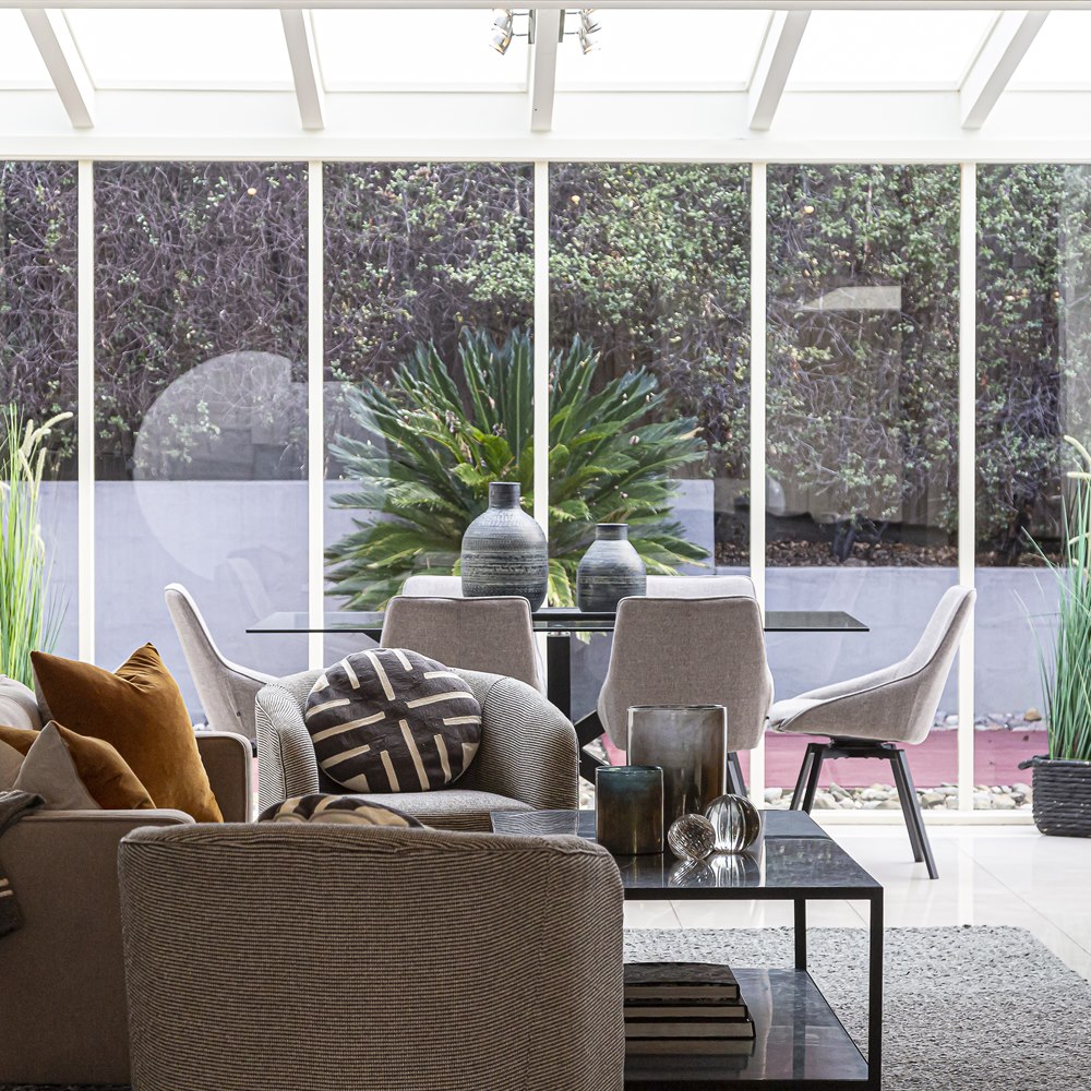 Modern indoor space with glass roof and garden
