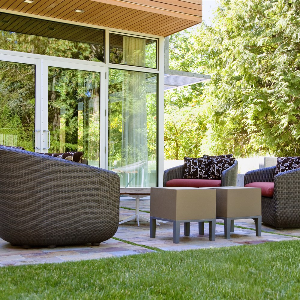 Outdoor patio with rattan chairs and greenery