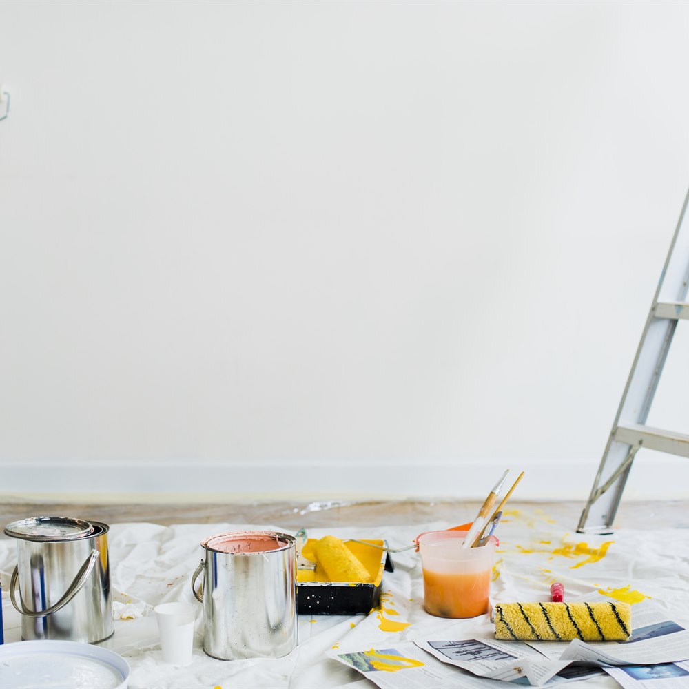 Painting supplies on floor with ladder and paint
