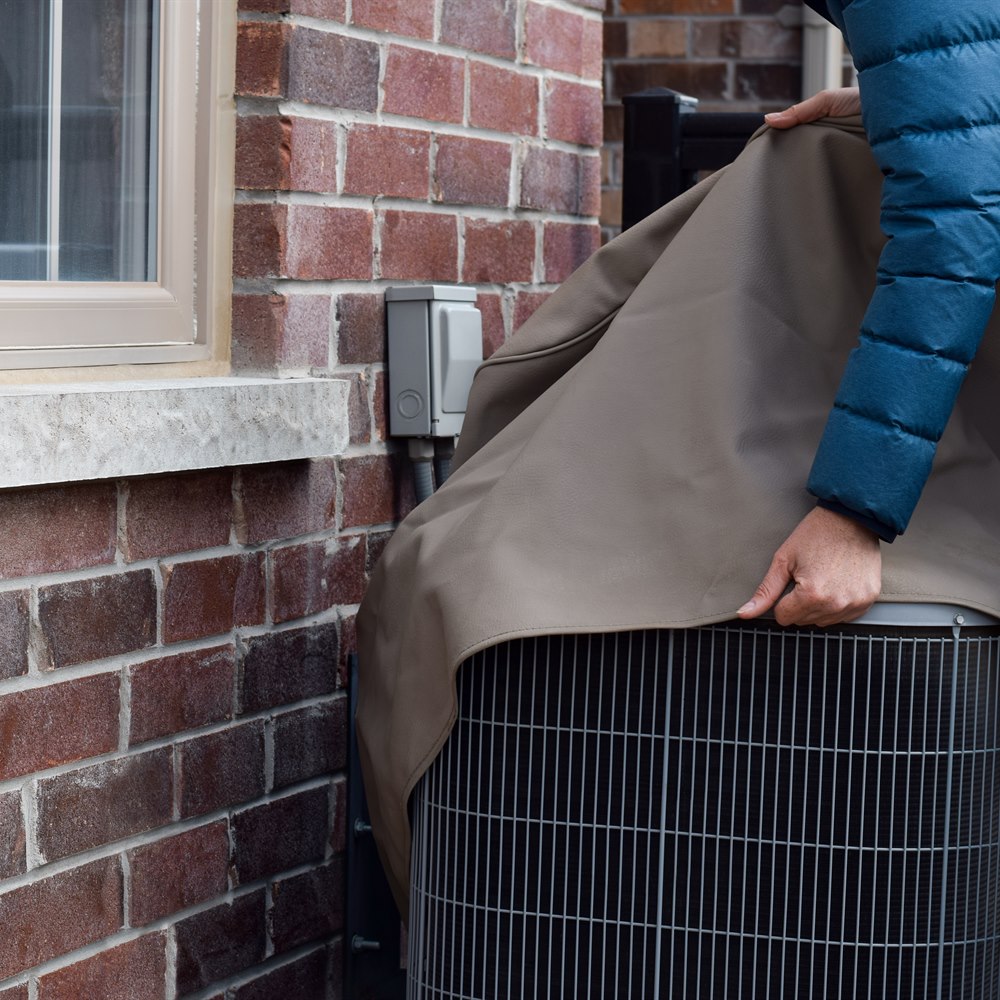 Person covering an outdoor air conditioning unit