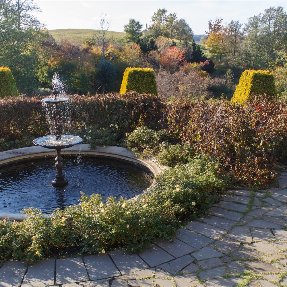 Picturesque garden landscape with stone fountain