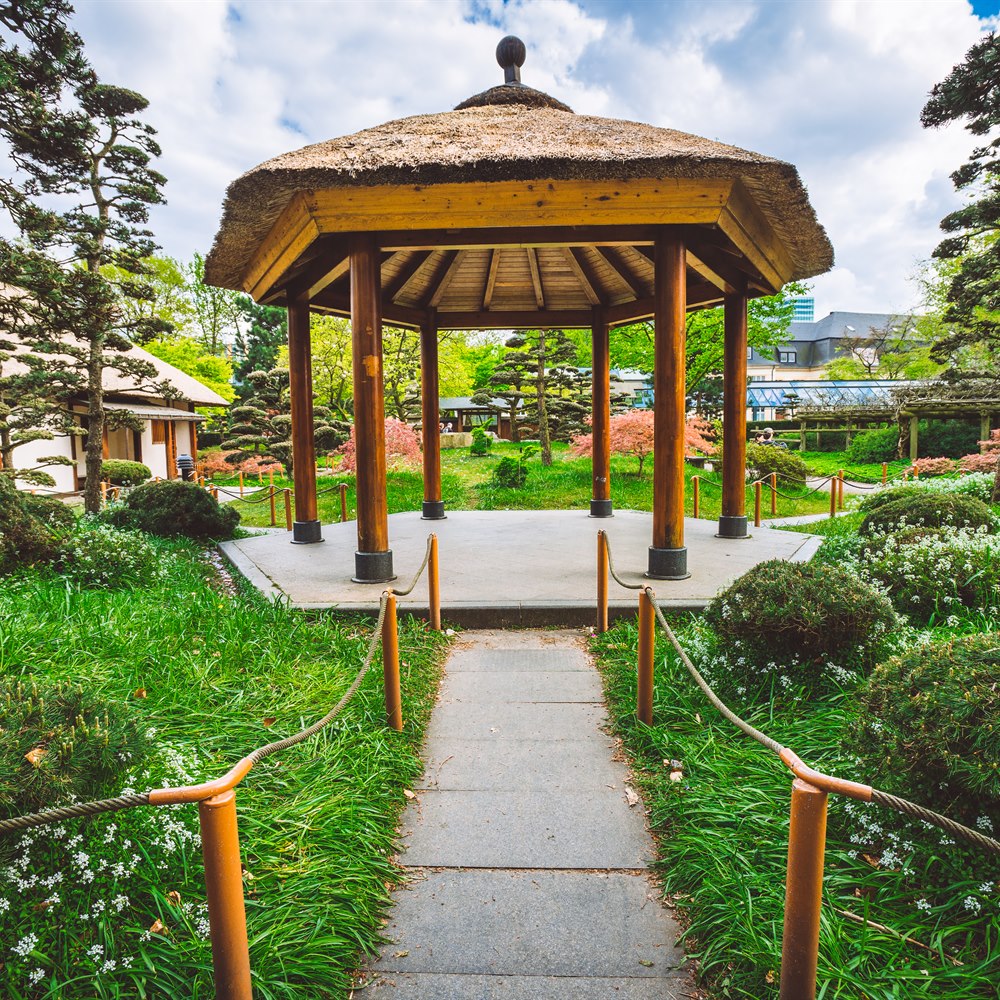 Picturesque thatched gazebo and garden path on close