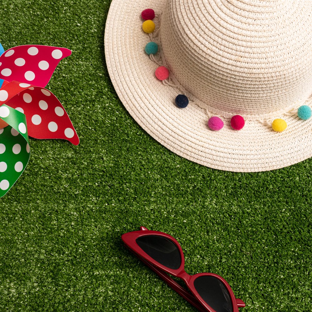 Pinwheel hat and sunglasses on green grass