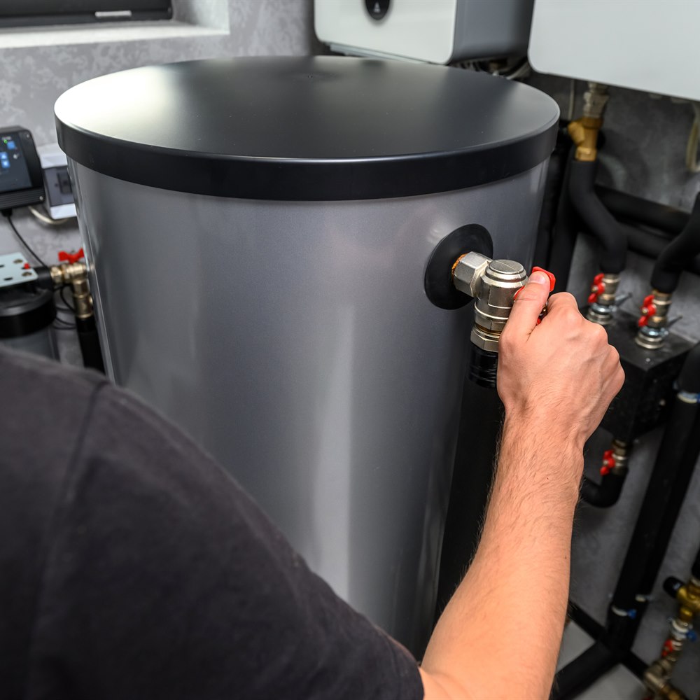 Plumber repairing valve on a hot water tank