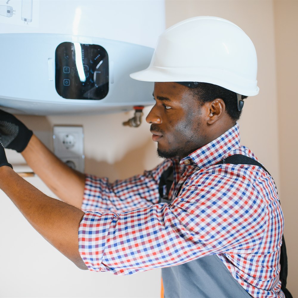 plumber-repairing-water-heater-in-home Plumber repairing water heater in home