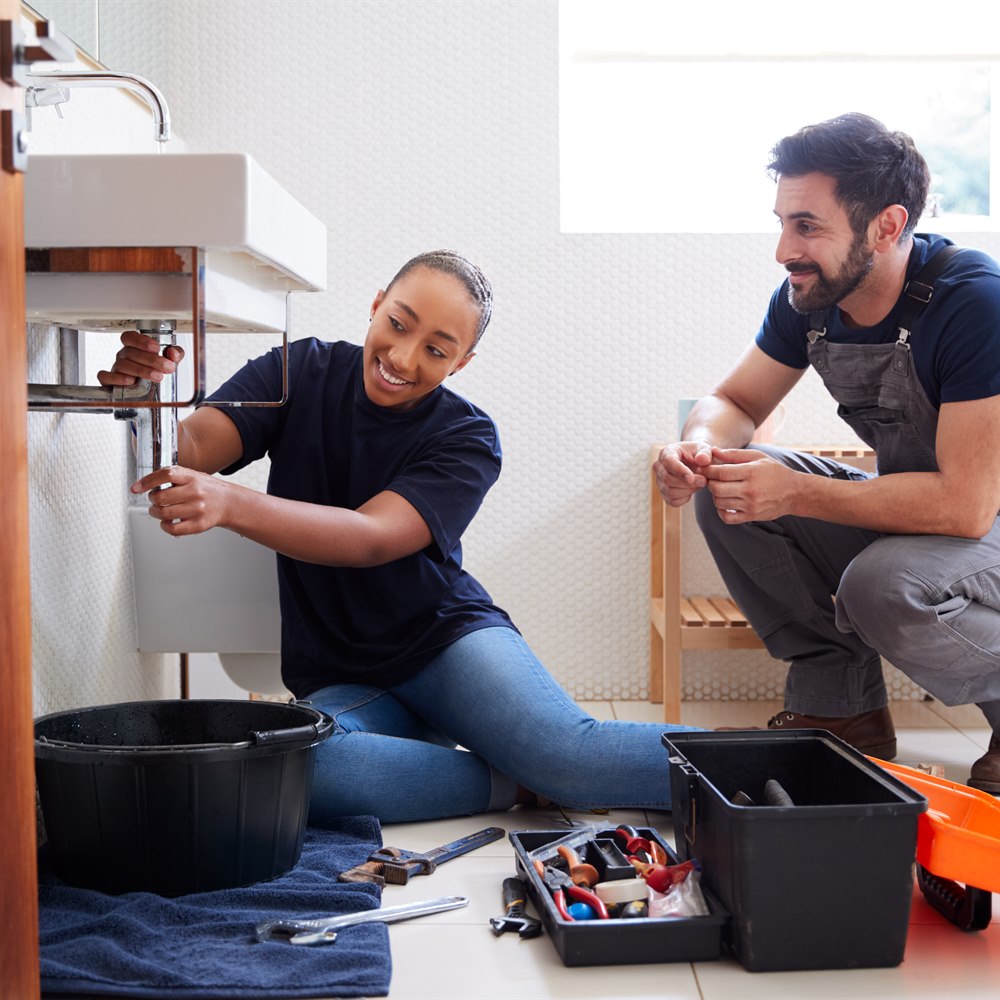 plumbers-working-on-sink-in-home-bathroom Plumbers working on sink in home bathroom