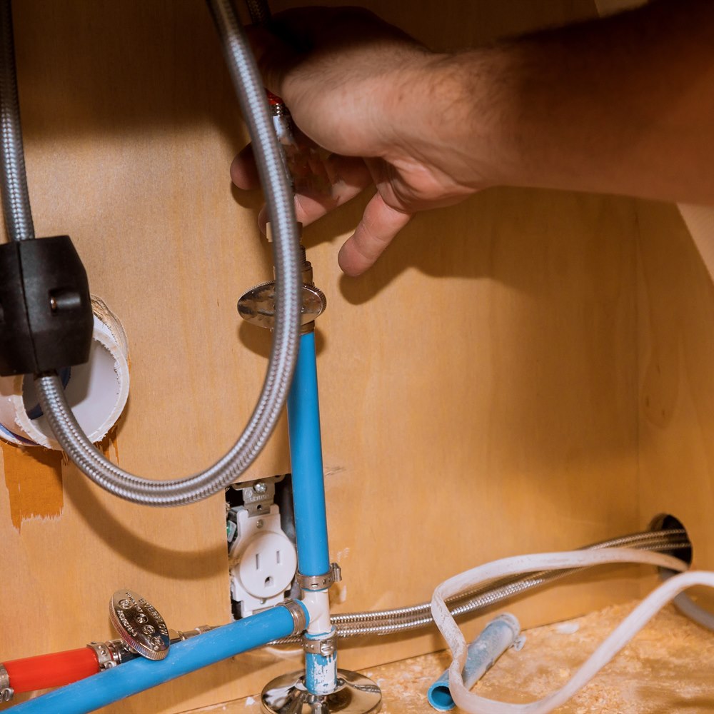 Plumbing installation under sink in cabinet