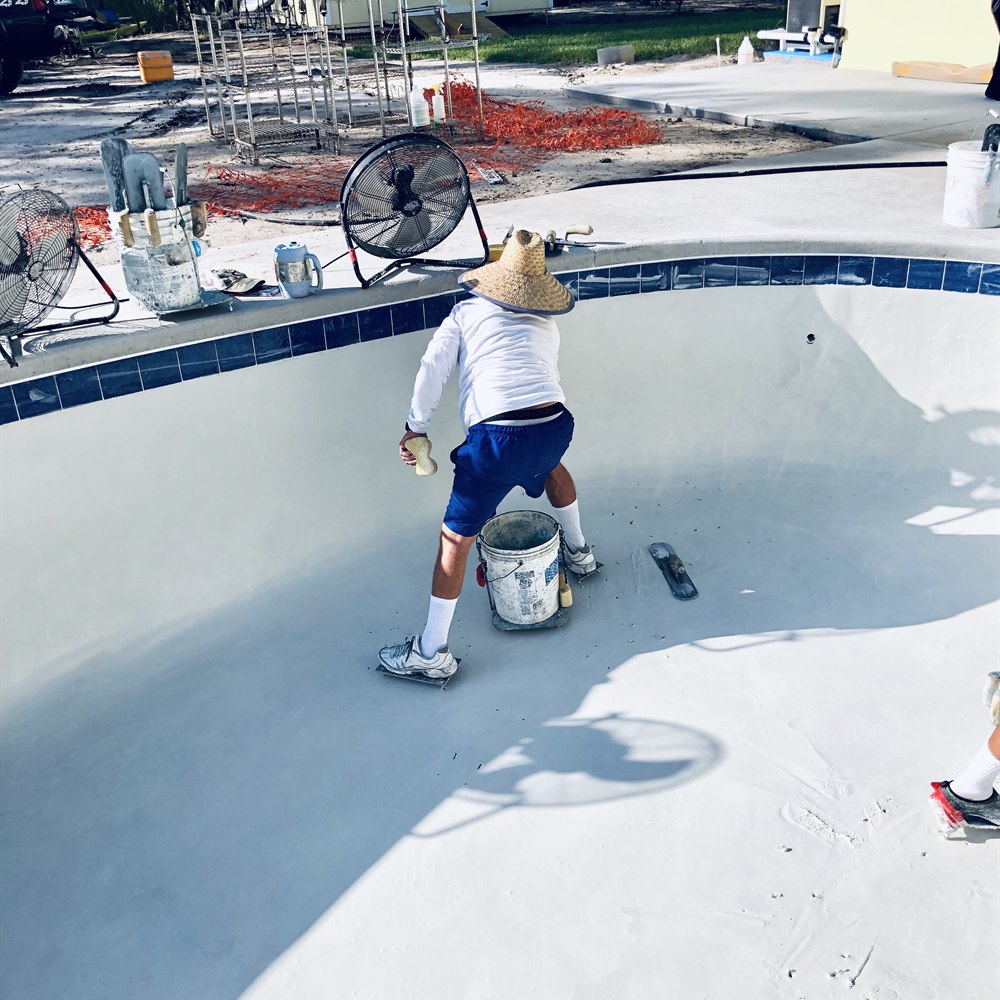 Pool under construction with two workers installing