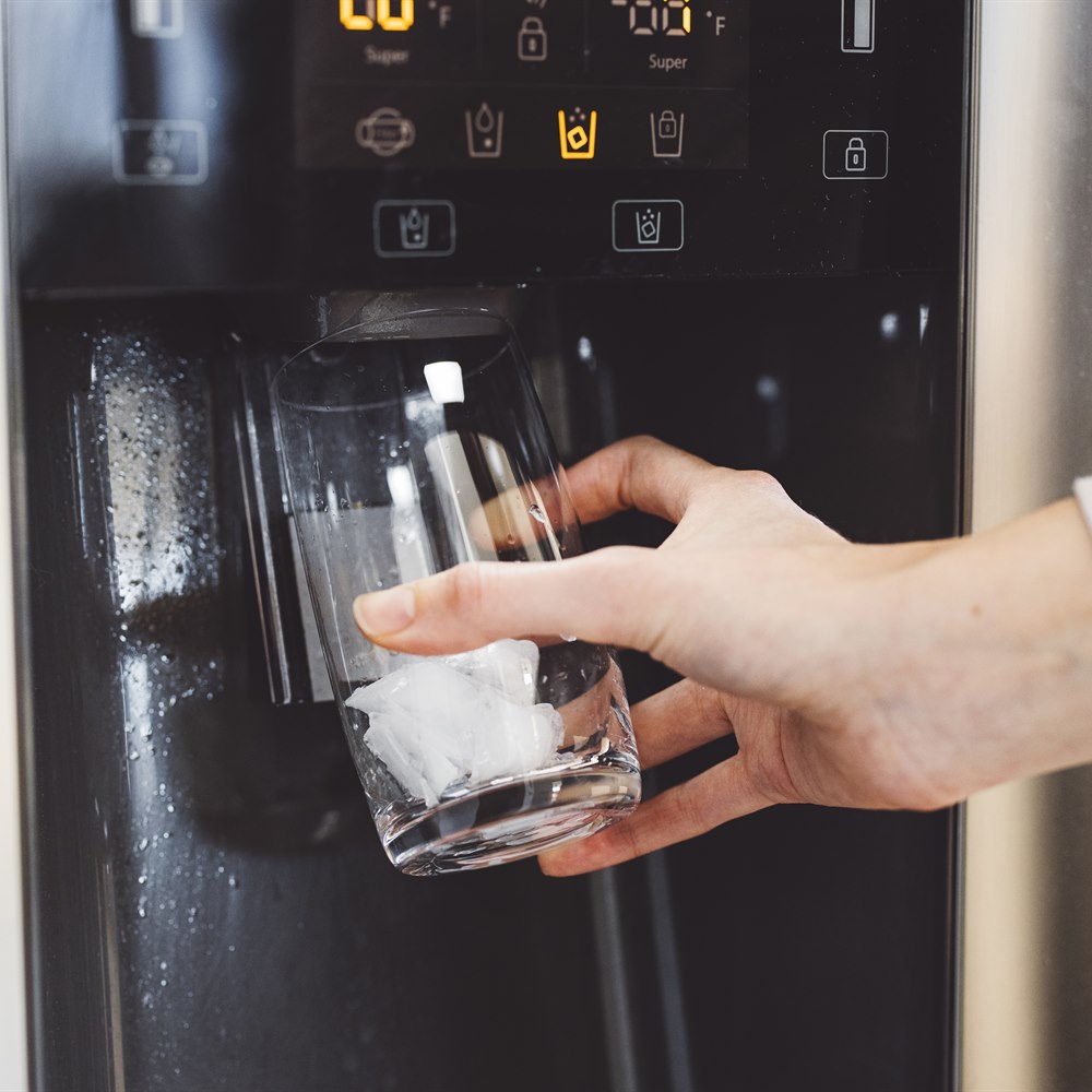 Refreshing ice water from modern refrigerator dispenser