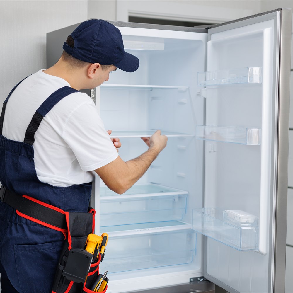 Refrigerator technician repairing appliance