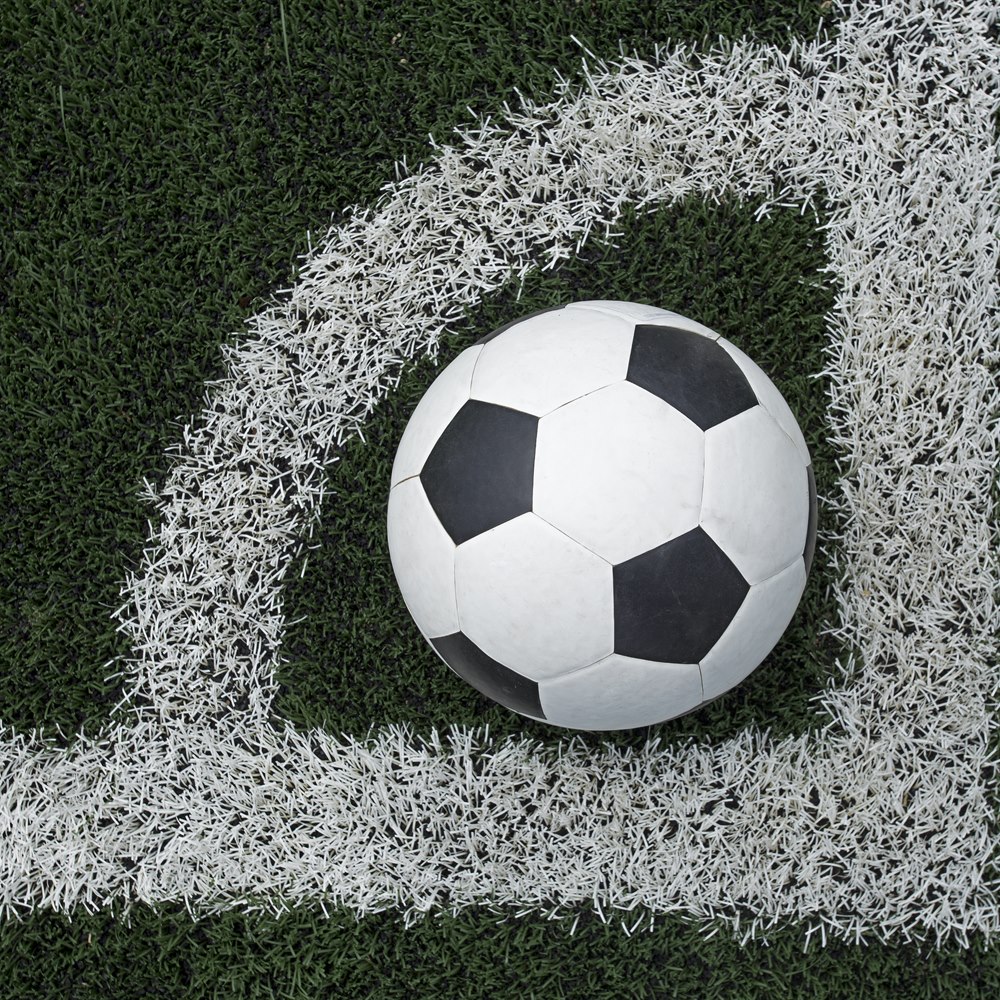 Soccer ball on green field with white lines