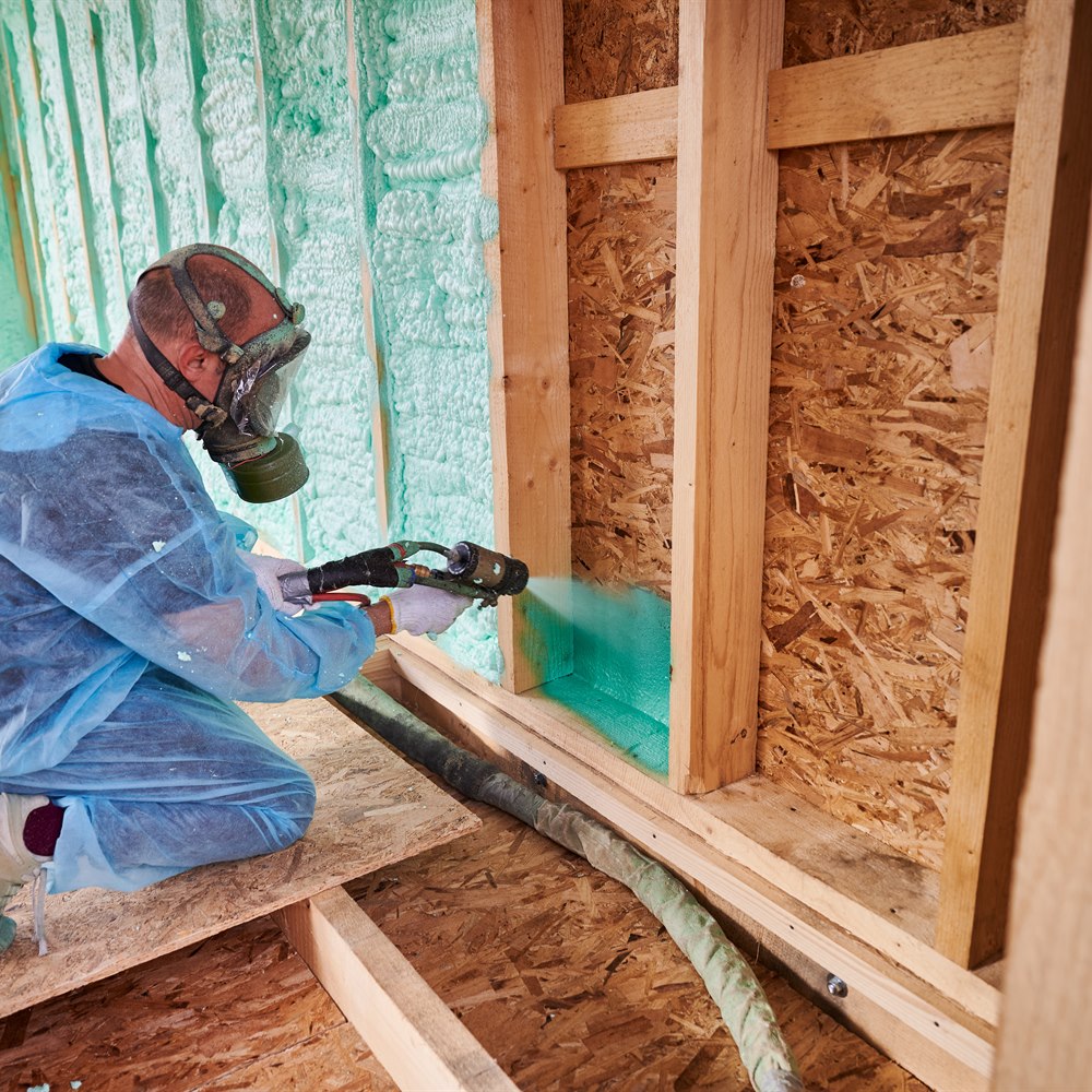 Spraying foam insulation into a wall