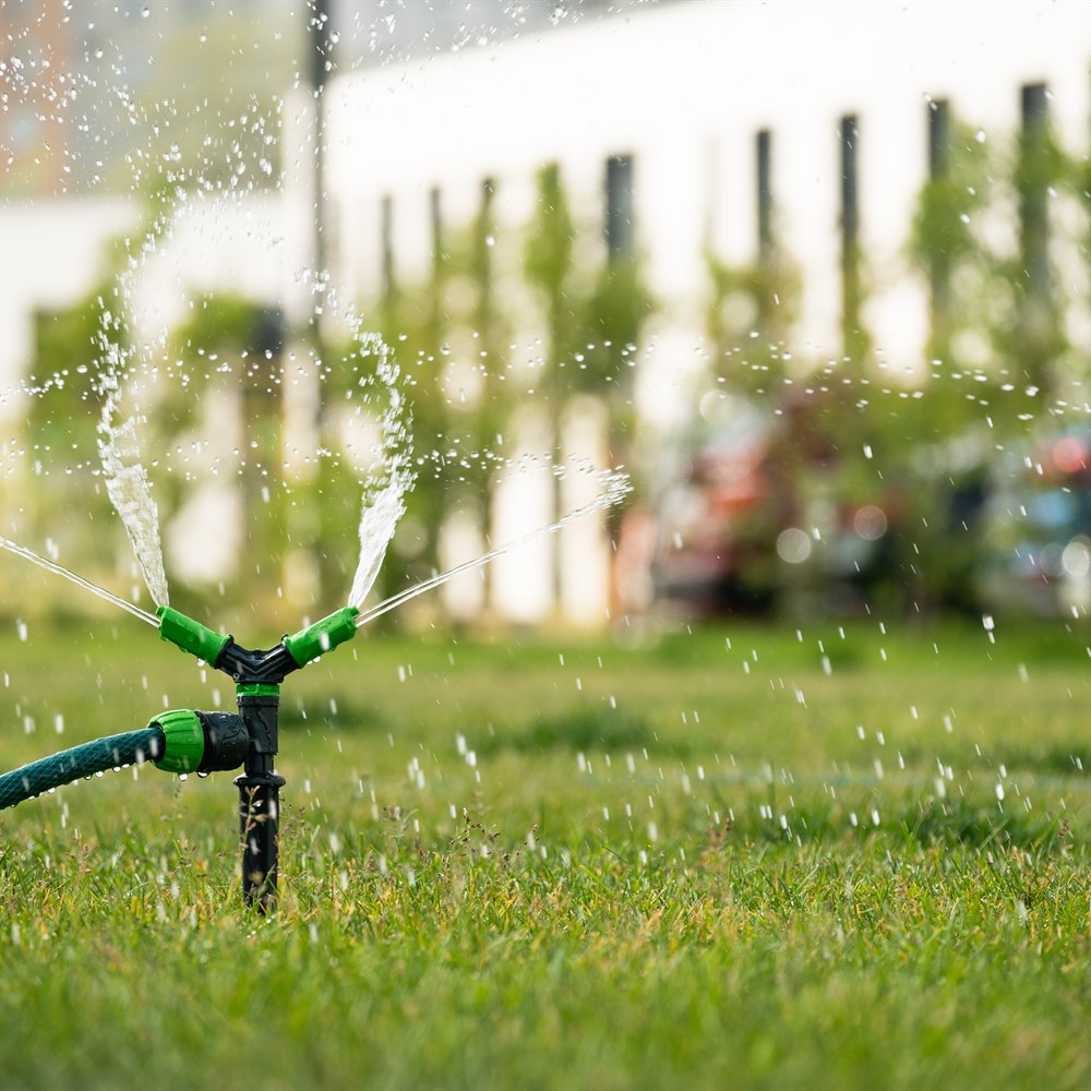 sprinkler-system-watering-green-lawn-in-residentia Sprinkler system watering green lawn