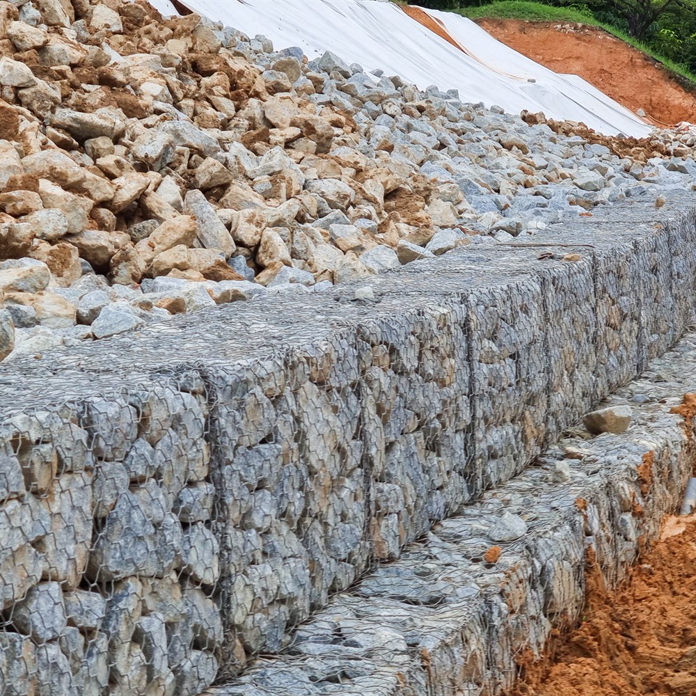Stacked stone in wire cages on brown soil