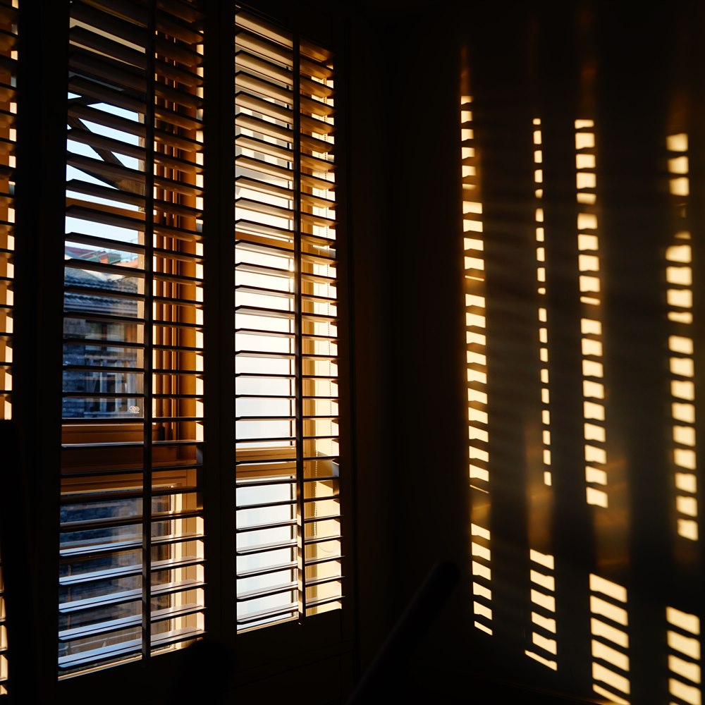 sunlight-streaming-through-window-blinds-at-sunris Sunlight streaming through window blinds