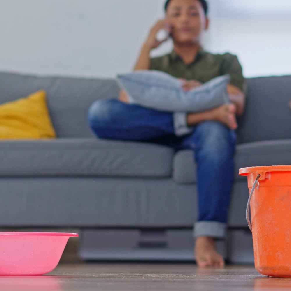 teen-on-couch-with-water-leak-and-buckets Teen on couch with water leak and buckets