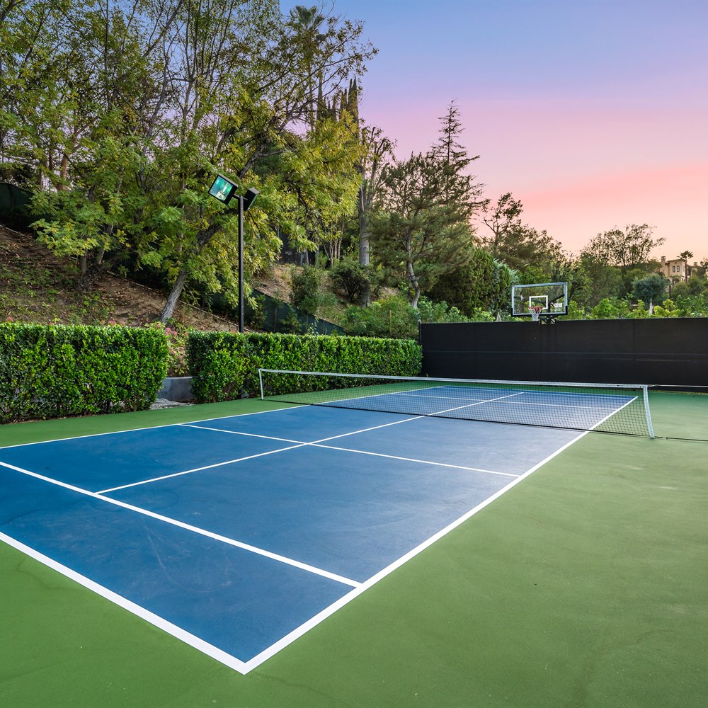Tennis court outdoors surrounded by trees