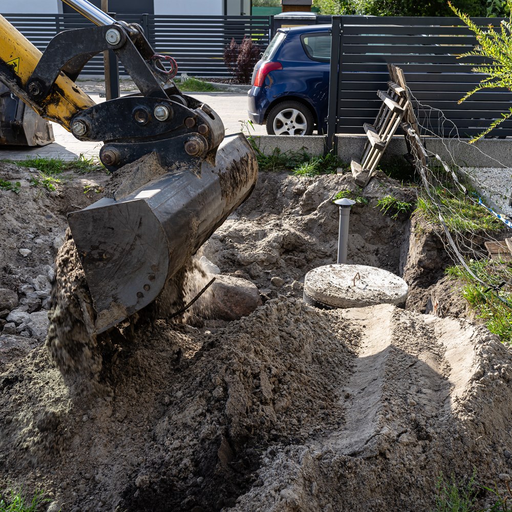 tractor-digging-a-trench-in-a-suburban-yard Tractor digging a trench in a suburban yard