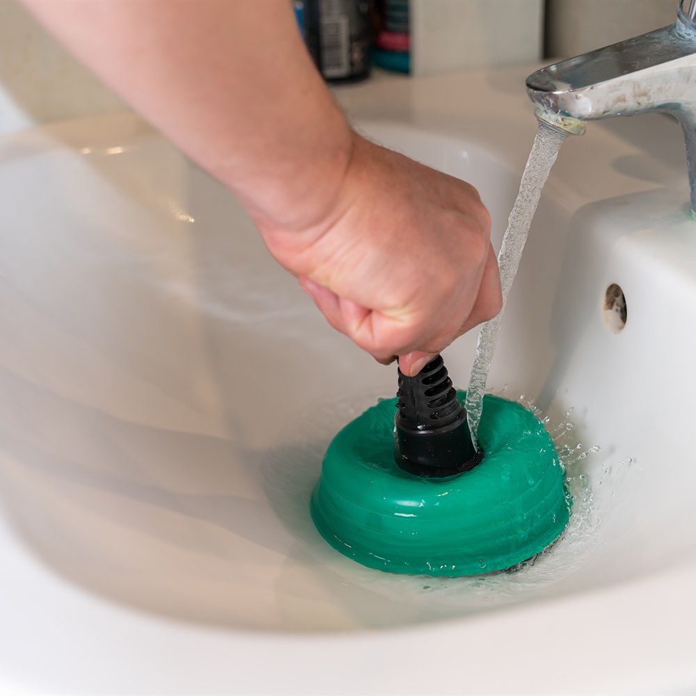 Unclogging a drain with a plunger at home