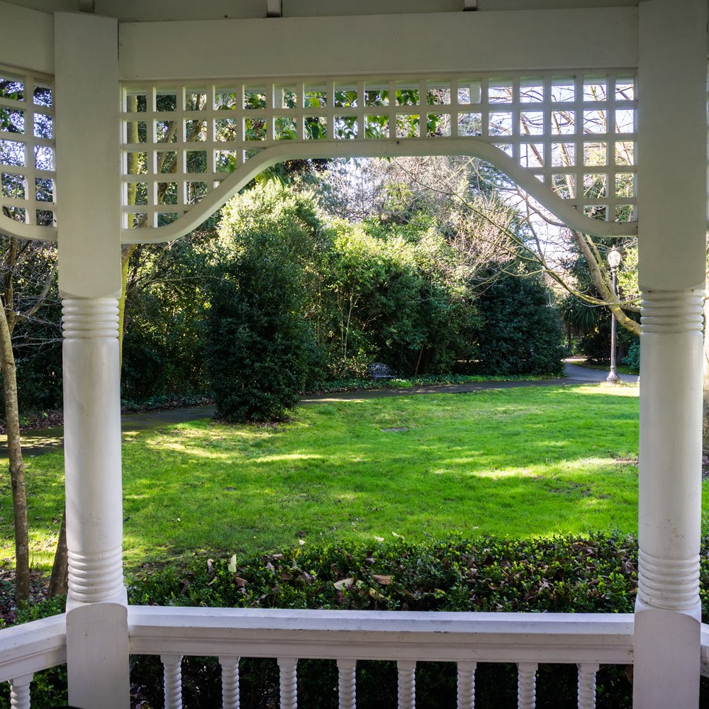 View from white gazebo onto green lawn