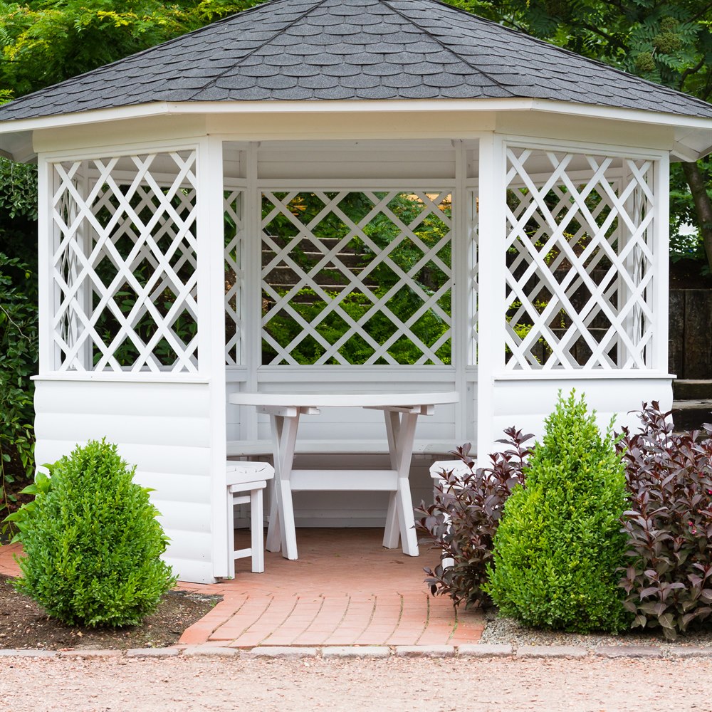 White gazebo structure surrounded by greenery
