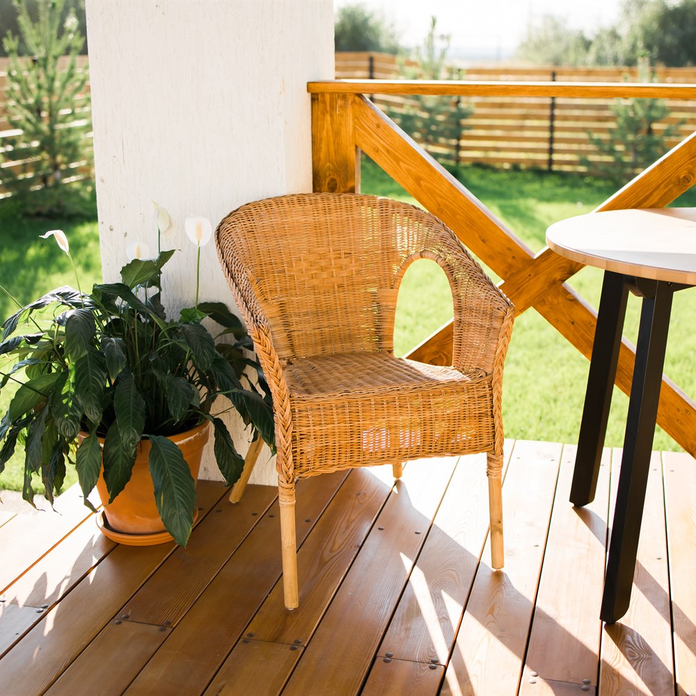 Wicker chair and peace lily on wooden deck