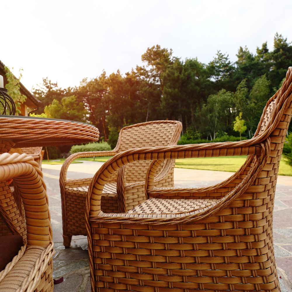 Wicker furniture on a stone patio at golden