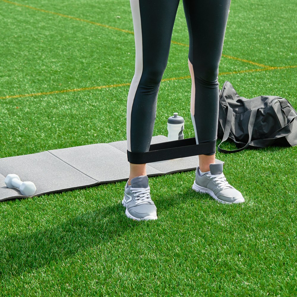 Woman exercising with resistance band in the park