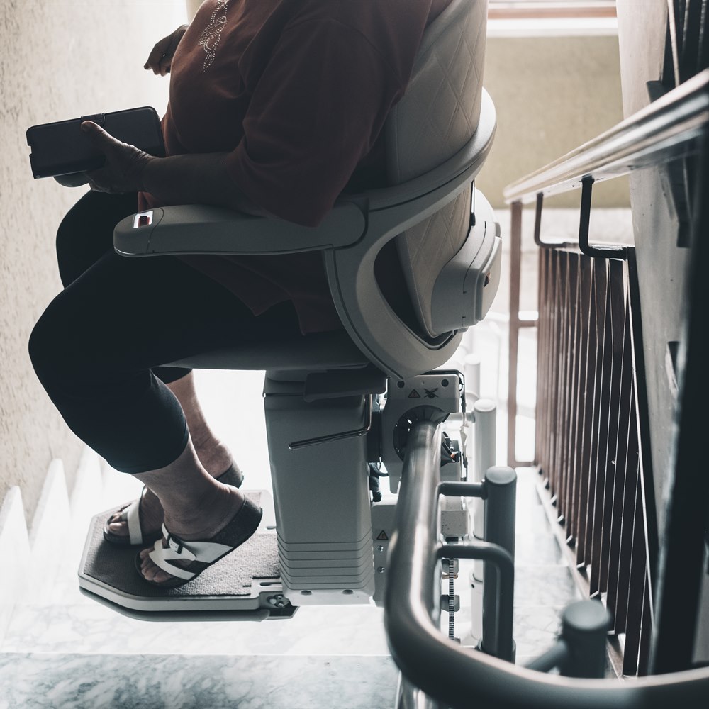 woman-using-stair-lift-in-home-interior Woman using stair lift in home interior