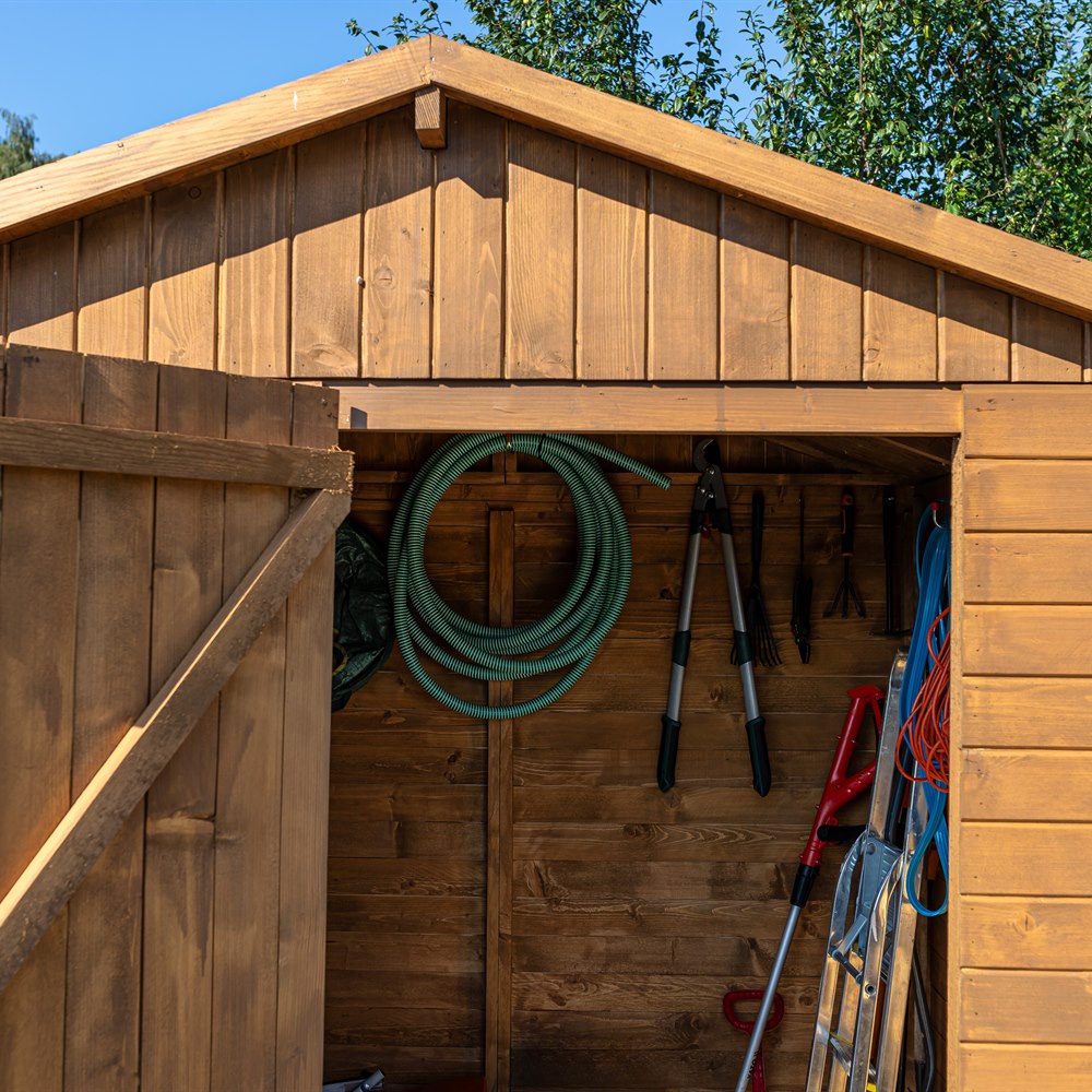 Wooden shed holding gardening equipment in a garden