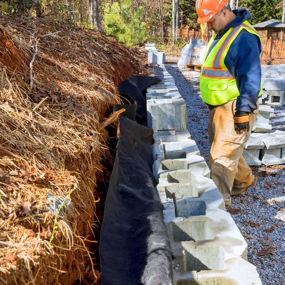 Worker assembling concrete blocks for retaining