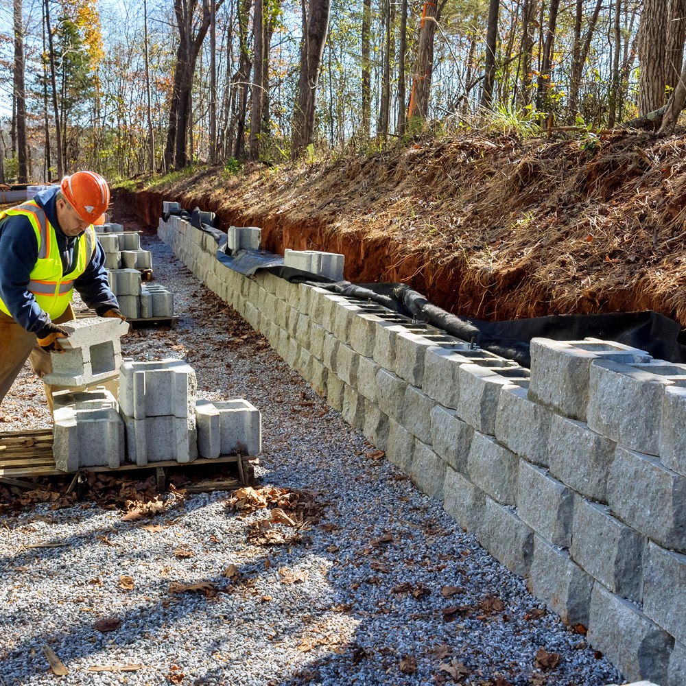 Worker building retaining wall on residential construction