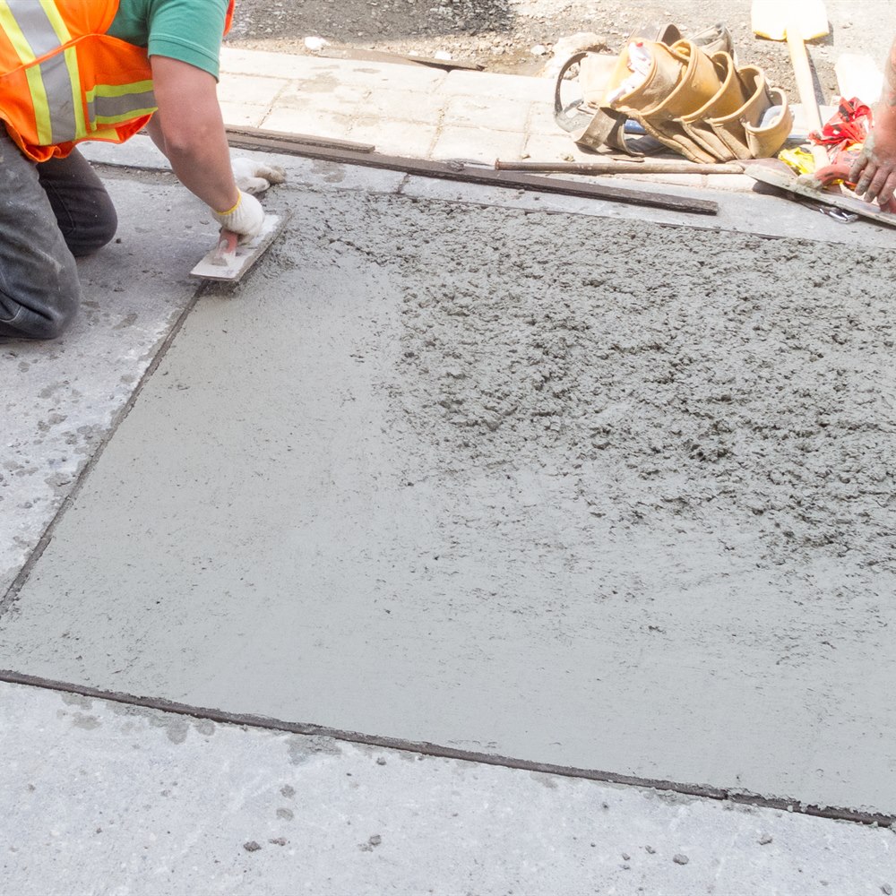 Workers finishing a concrete sidewalk